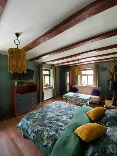 a bedroom with two beds in a room with green walls at Zagroda AlpakoTerapii in Świeradów-Zdrój