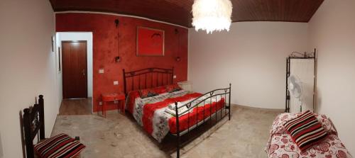 a bedroom with a bed with a red wall at La casa sul tetto, Room's & Glamping in Recanati