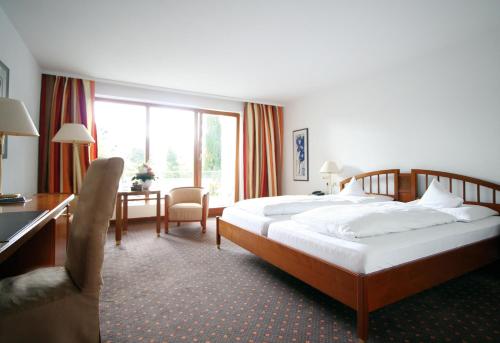 a hotel room with a large bed and a desk and a desk at Romantik Hotel Johanniter-Kreuz in Überlingen
