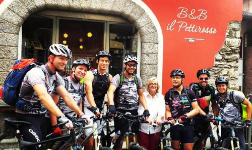 a group of people standing in front of a building with their bikes at B&B Il Pettirosso in Malonno