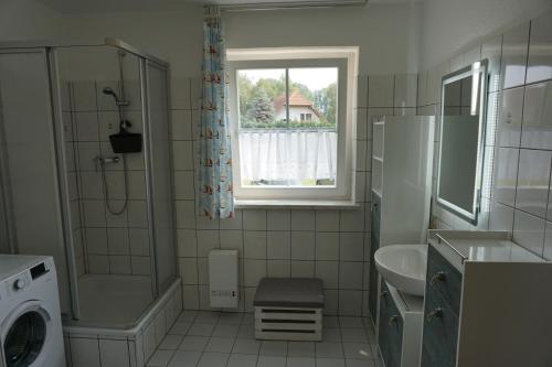 a small bathroom with a sink and a window at Maritim #1 in Peenemünde