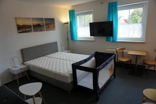 a bedroom with a bed and a flat screen tv at Maritim #1 in Peenemünde
