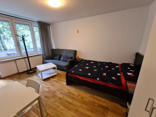 een slaapkamer met een bed, een bank en een stoel bij MirrorRoom PL CityCenter in Warschau