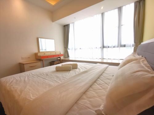 een slaapkamer met een groot wit bed en een raam bij R&F Princess Cove by Maco Home in Johor Bahru