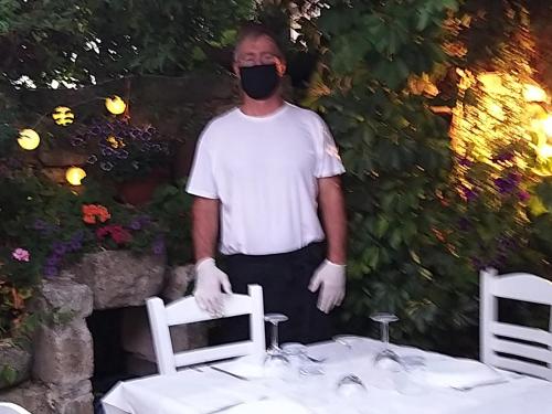 a man wearing a mask standing next to a table at Ble Mavi - Studio for 2 in Vouni