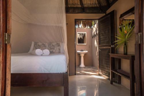 a bedroom with a bed and a sink in it at Playa Esperanza Tulum in Tulum