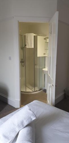 a bedroom with a bed and a glass shower at Dunskaith Villa in Inverness