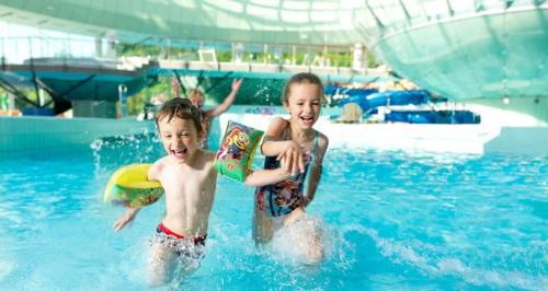 two young children playing in a swimming pool at Villa Aina Boutique Hotel in Laško