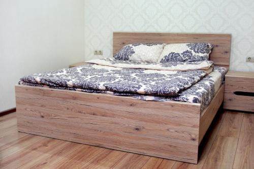 ein Bett mit einem Holzrahmen in einem Zimmer in der Unterkunft Apartament Vasilya Porika 48 Street Vinnytsya,Ukraine in Winnyzja
