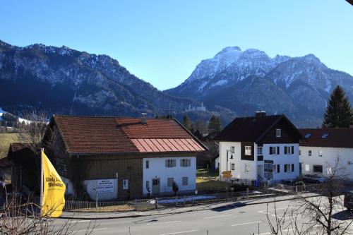a group of buildings with mountains in the background at Das Schwanstein in Schwangau