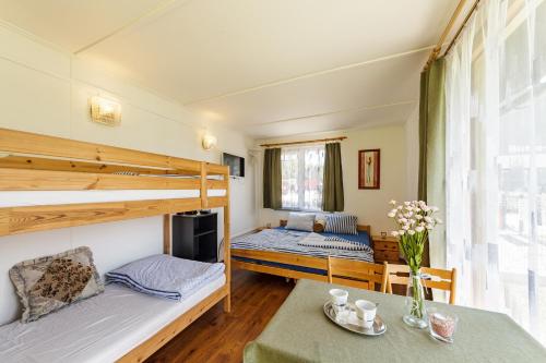 een kamer met 2 stapelbedden en een tafel bij Camping u Kukačků in Horní Planá