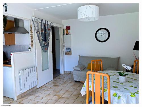une cuisine et une salle à manger avec une table dans l'établissement Cabourg, Appartement plain pied avec terrasse accès direct à la plage, à Cabourg