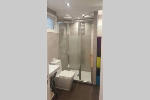 een badkamer met een toilet, een wastafel en een douche bij Acogedor apartamento familiar in Marbella