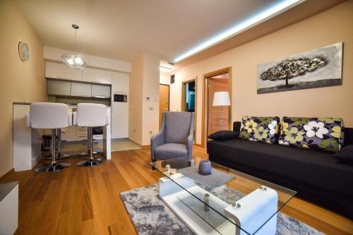ein Wohnzimmer mit einem schwarzen Sofa und einem Tisch in der Unterkunft Apartman Pavle in Zlatibor