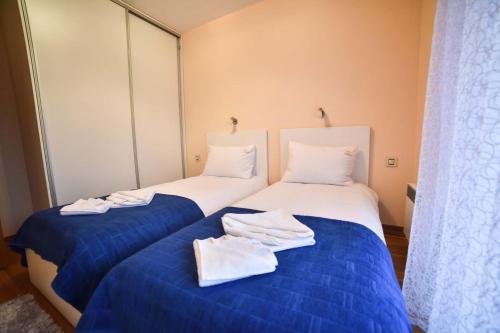 2 Betten in einem Zimmer mit Handtüchern darauf in der Unterkunft Apartman Pavle in Zlatibor