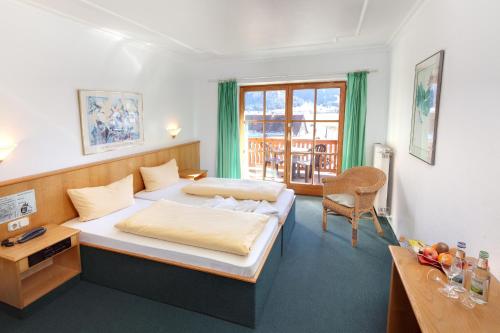 a bedroom with a bed and a desk and a chair at Das Schwanstein in Schwangau