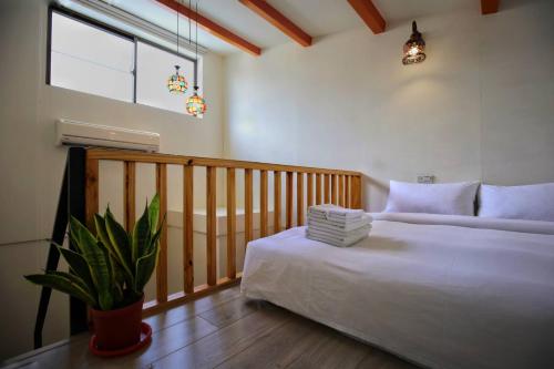 a bedroom with a bed and a potted plant at Windhouse B&B in Tainan