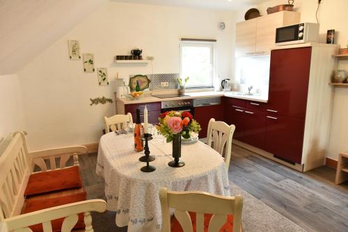 a kitchen with a table with flowers on it at Ferienwohnung Axcher Hof in Weitersborn