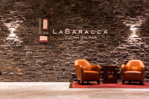 two chairs and a table in front of a brick wall at Park Inn by Radisson Lübeck in Lübeck