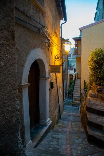an alley with an arch in a stone building at Palazzo del Diplomatico in Belmonte Calabro