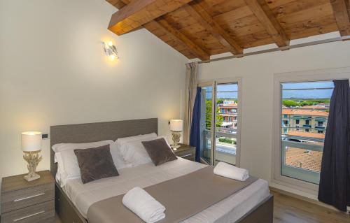 Attico panoramico fronte mare في ليدو دي كامايوري: غرفة نوم بسرير كبير وبلكونة