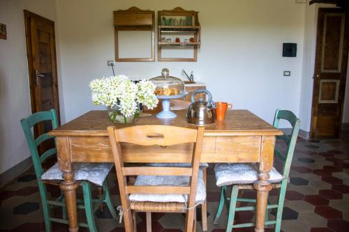 a wooden table with a tea kettle and flowers on it at Palazzo del Diplomatico in Belmonte Calabro