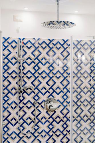 a bathroom with a shower with blue and white tiles at Monte Brusara Relais in Ravello