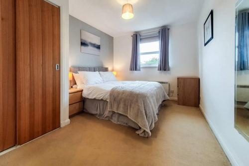 a small bedroom with a bed and a window at Hilton Wynd Apartment in Rosyth