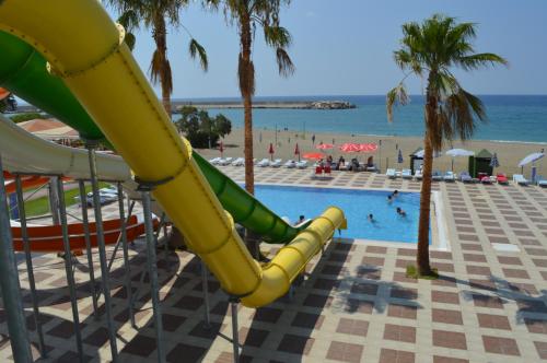 a slide at a resort with a pool and a beach at Bülent Kocabaş-Selinus Beach Club Hotel in Gazipasa