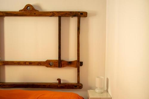 a wooden shelf on a wall next to a bed at Palazzo del Diplomatico in Belmonte Calabro