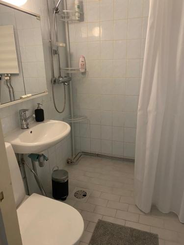 a white bathroom with a sink and a toilet at Apartments ”Enkeli” in Kotka