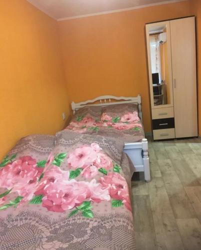 ザドンスクにあるApartment on Sovetskaya 50Aのベッドルーム1室(ピンクの花が咲くベッド1台付)