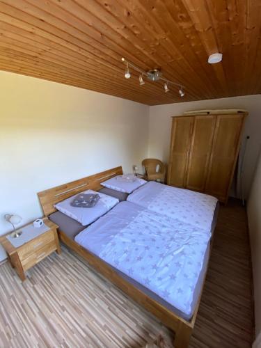 a large bed in a room with a wooden ceiling at Am Grünenplatz 63 in Wermelskirchen