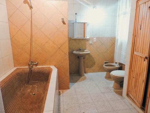 a bathroom with a shower and a toilet and a sink at Hostel Lazy Gaucho in Paysandú