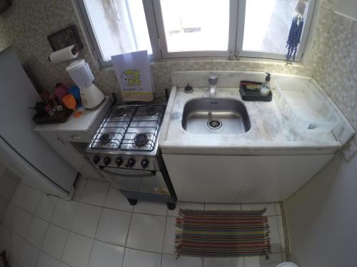 Una pequeña cocina con fregadero y estufa. en Casas Maragogi 12, en Maragogi