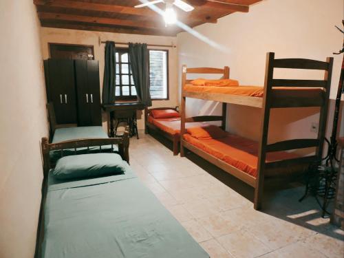派桑杜Hostel Lazy Gaucho的客房设有三张双层床和一扇窗户。