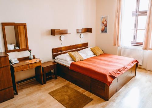 a bedroom with a bed and a dresser at Hotel Dar in Prague