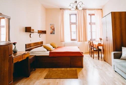 ein Schlafzimmer mit einem Bett, einem Tisch und einem Sofa in der Unterkunft Hotel Dar in Prag