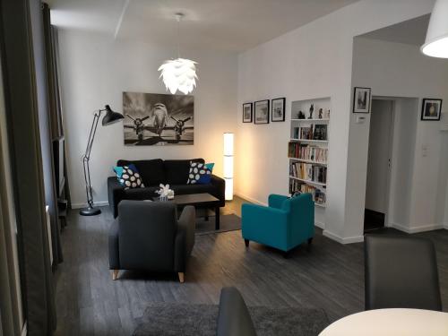 - un salon avec un canapé et un fauteuil bleu dans l'établissement Le FOURNIRUE T2, à Metz