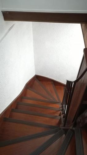a wooden staircase with a wooden floor and a white wall at Le FOURNIRUE T2 in Metz