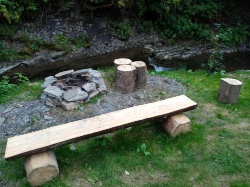 a wooden bench sitting next to a pile of logs at Domek in Reľov