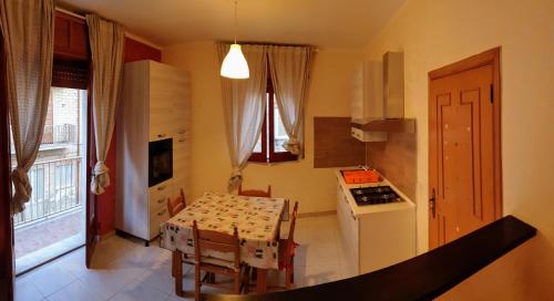 uma cozinha com uma mesa e uma pequena cozinha com uma mesa e cadeiras em Appartamento In Paese em Niscemi