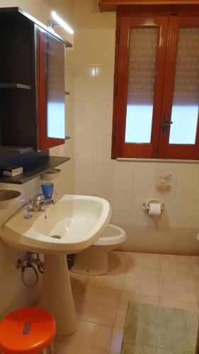 ein Badezimmer mit einem weißen Waschbecken und einem WC in der Unterkunft Appartamento In Paese in Niscemi