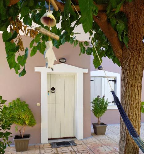 a white door in a building with a tree at "Villa Kanavos" apts in Matala