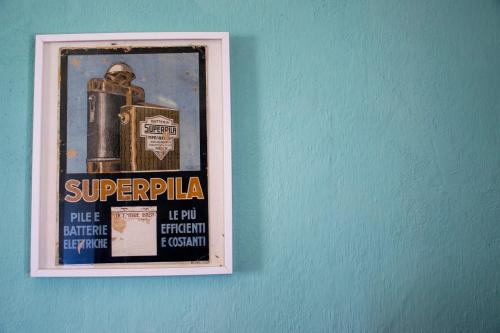 a picture of a poster on a blue wall at Palazzo del Diplomatico in Belmonte Calabro