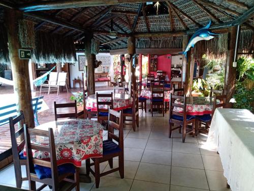 restauracja ze stołami i krzesłami oraz niebieskim delfinem na suficie w obiekcie Pousada Bawa w mieście Ubatuba