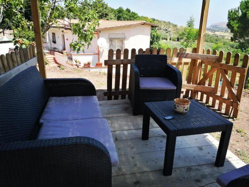 a patio with two chairs and a coffee table at L'Opuntia sul lago in Caccamo