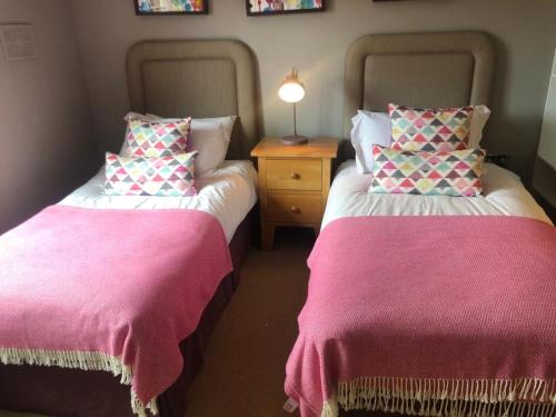 two beds sitting next to each other in a room at Cromwells Court in Kenmare