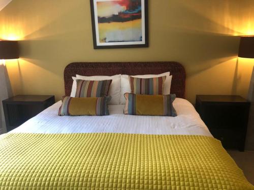 a bedroom with a large bed with two pillows at Cromwells Court in Kenmare