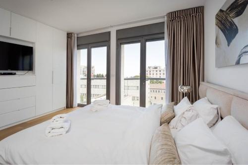 - une chambre avec un lit blanc et une grande fenêtre dans l'établissement Rav Kook Luxury Complex - 4BDR, à Jérusalem